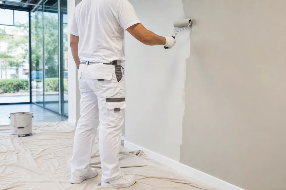 Painter rolling a wall in a modern office space